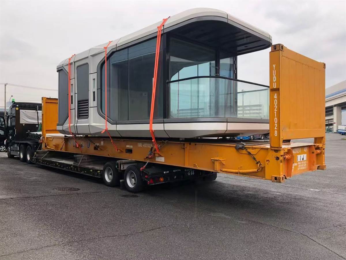 Space capsule cabin loaded on flat rack trailer