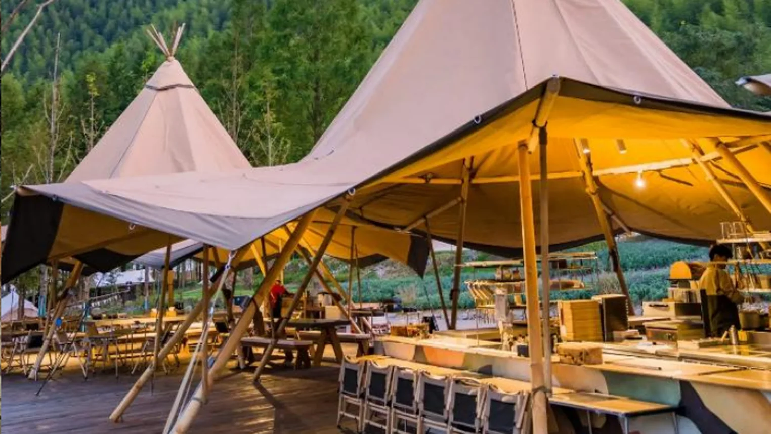 Outdoor dining pavilion with communal seating in a natural resort setting