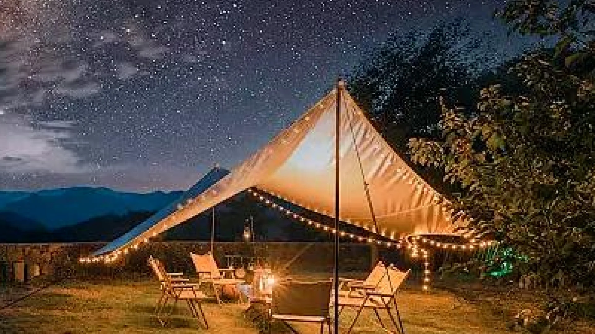 Warmly illuminated outdoor lounge and gathering space beneath the night sky