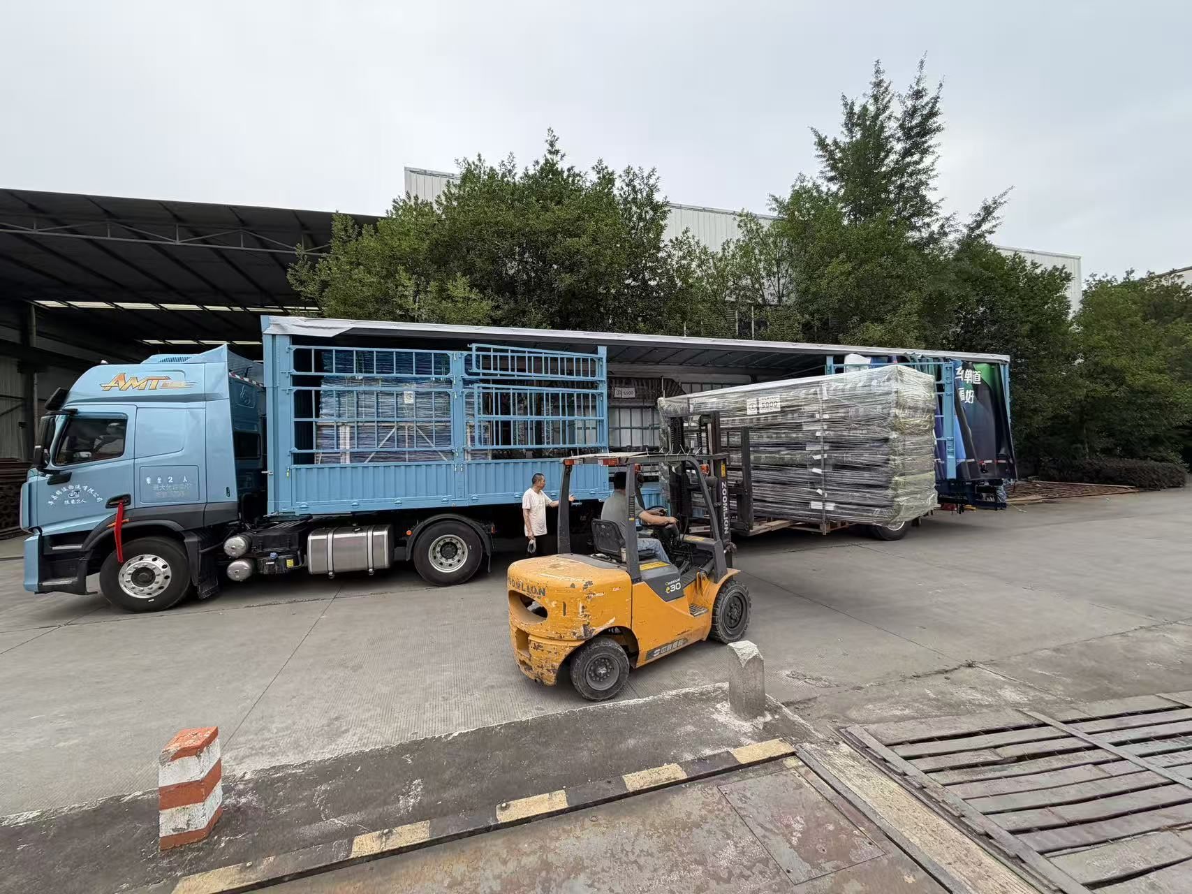 Forklift positioning protected modular components beside a truck