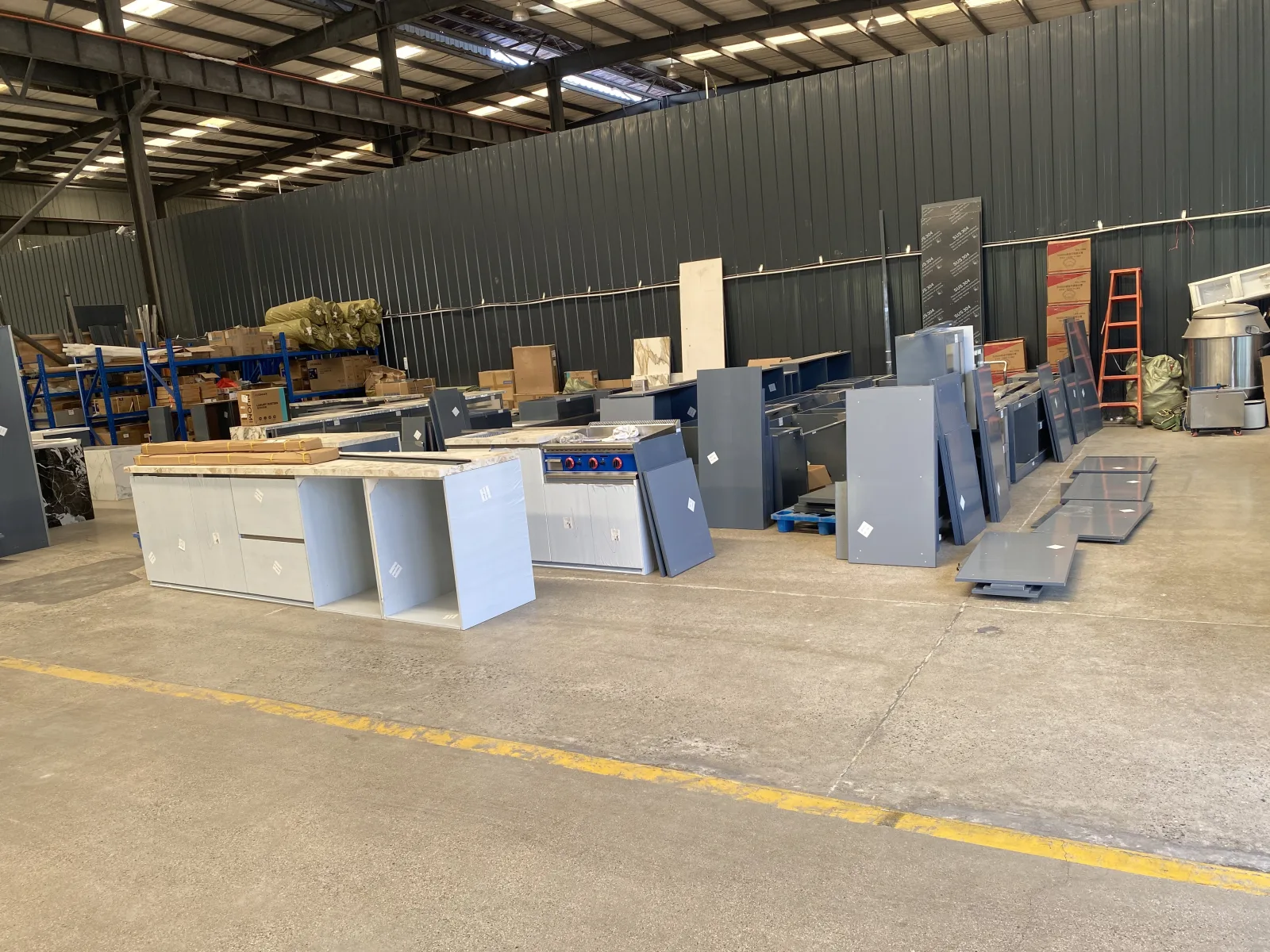 Prepared outdoor kitchen cabinet units and components in a factory area